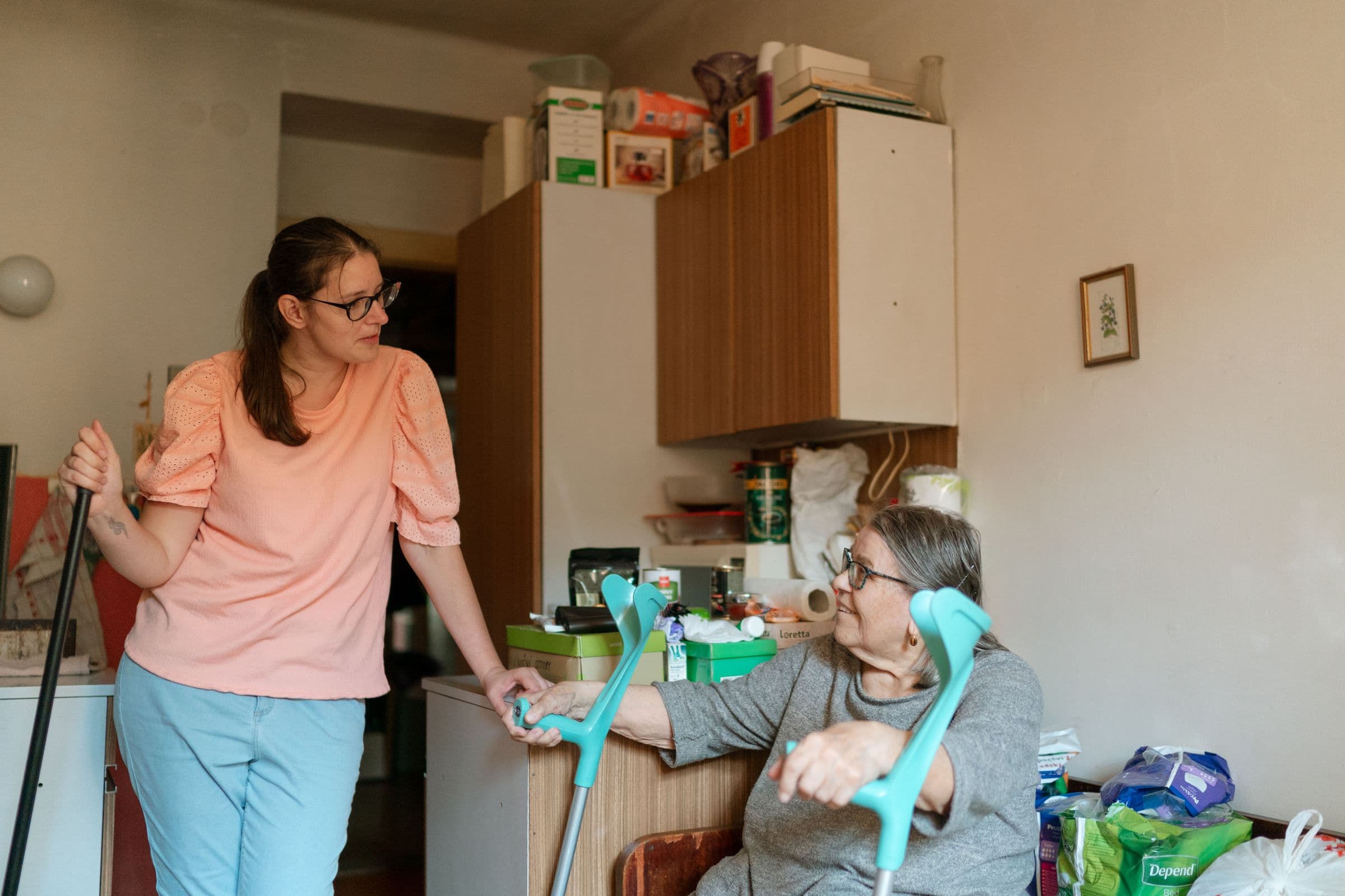 A caregiver assisting an older adult at home.